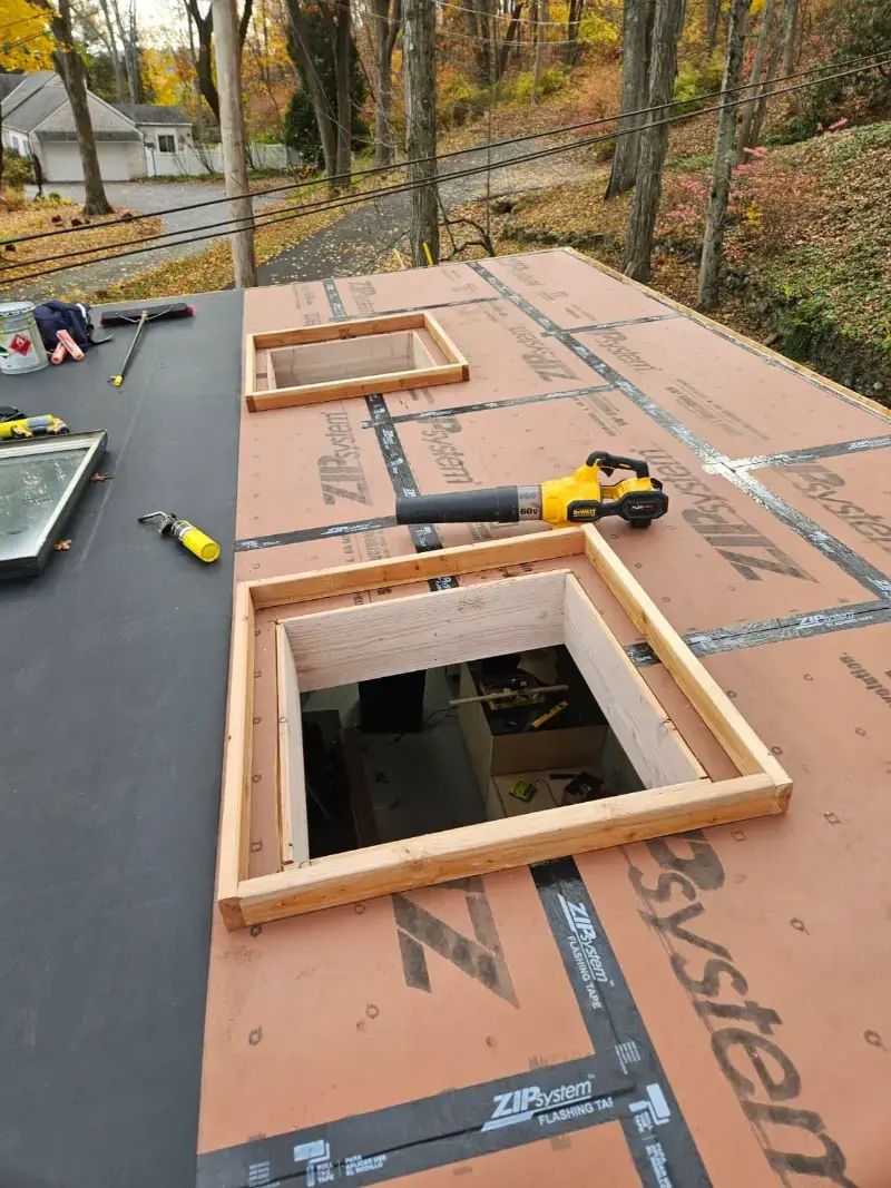 Roofing contractor installing asphalt shingles on a New York residential roof