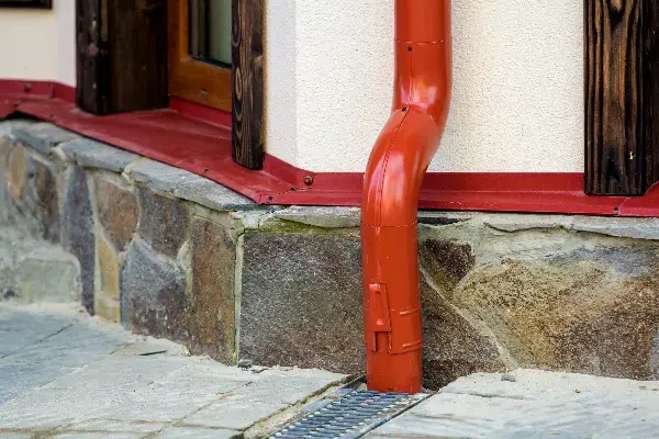 Gutter downspout connected to a buried drain line