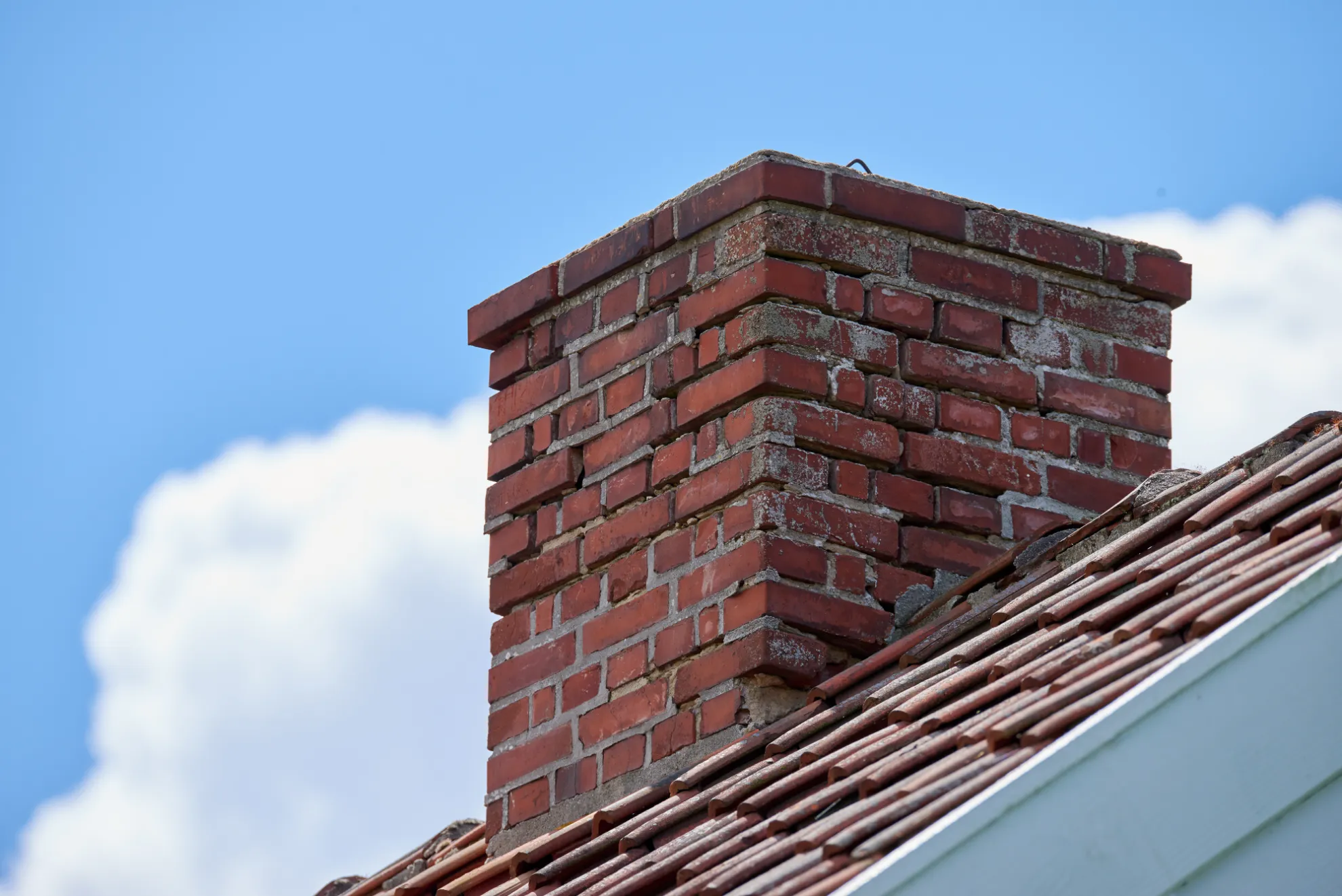 Mason rebuilding a brick chimney crown on a New York home