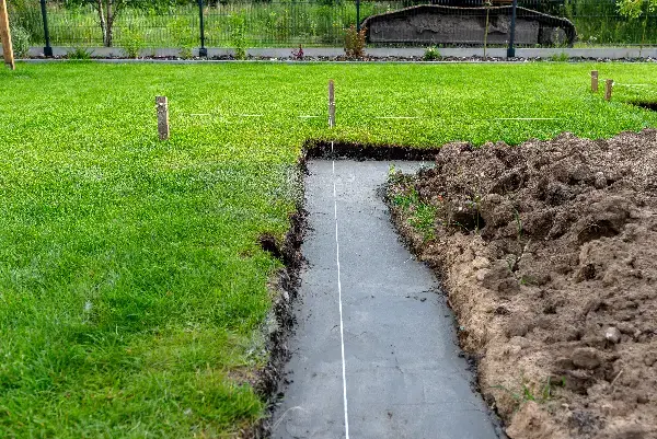 Open French drain trench dug to slope on a New York property